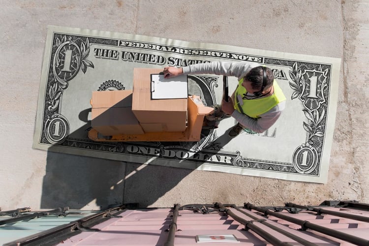 Operador moviendo cajas sobre billete de dólar representando costo logístico total