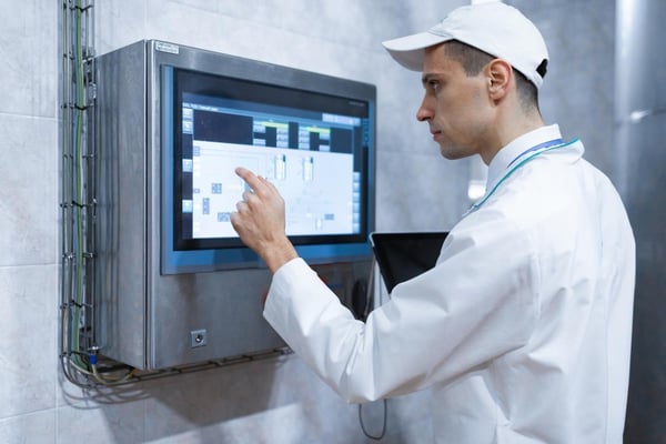 Operador revisa panel de control térmico en sistema de transporte refrigerado